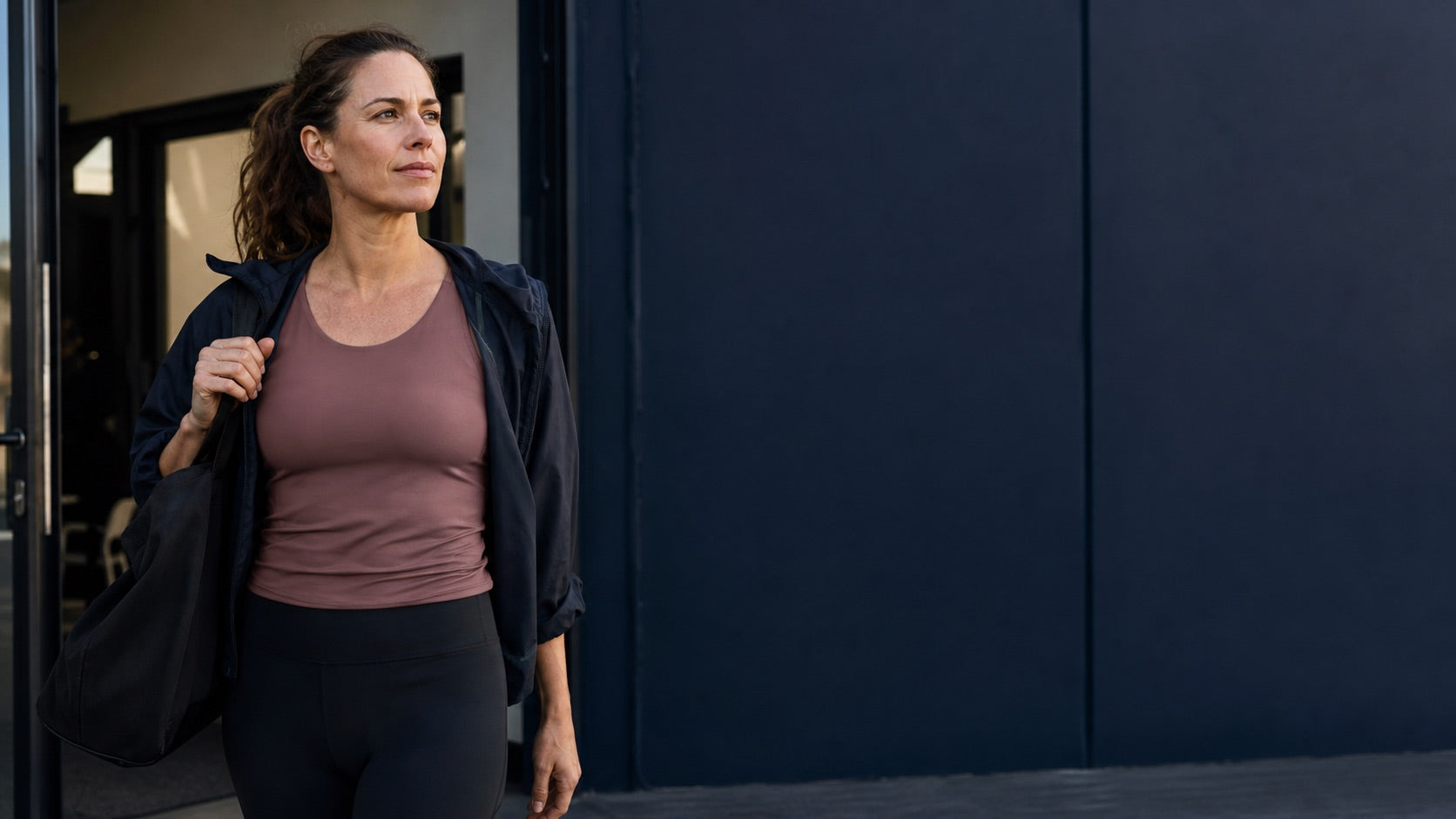 Woman leaving a strength session with a calm, confident expression